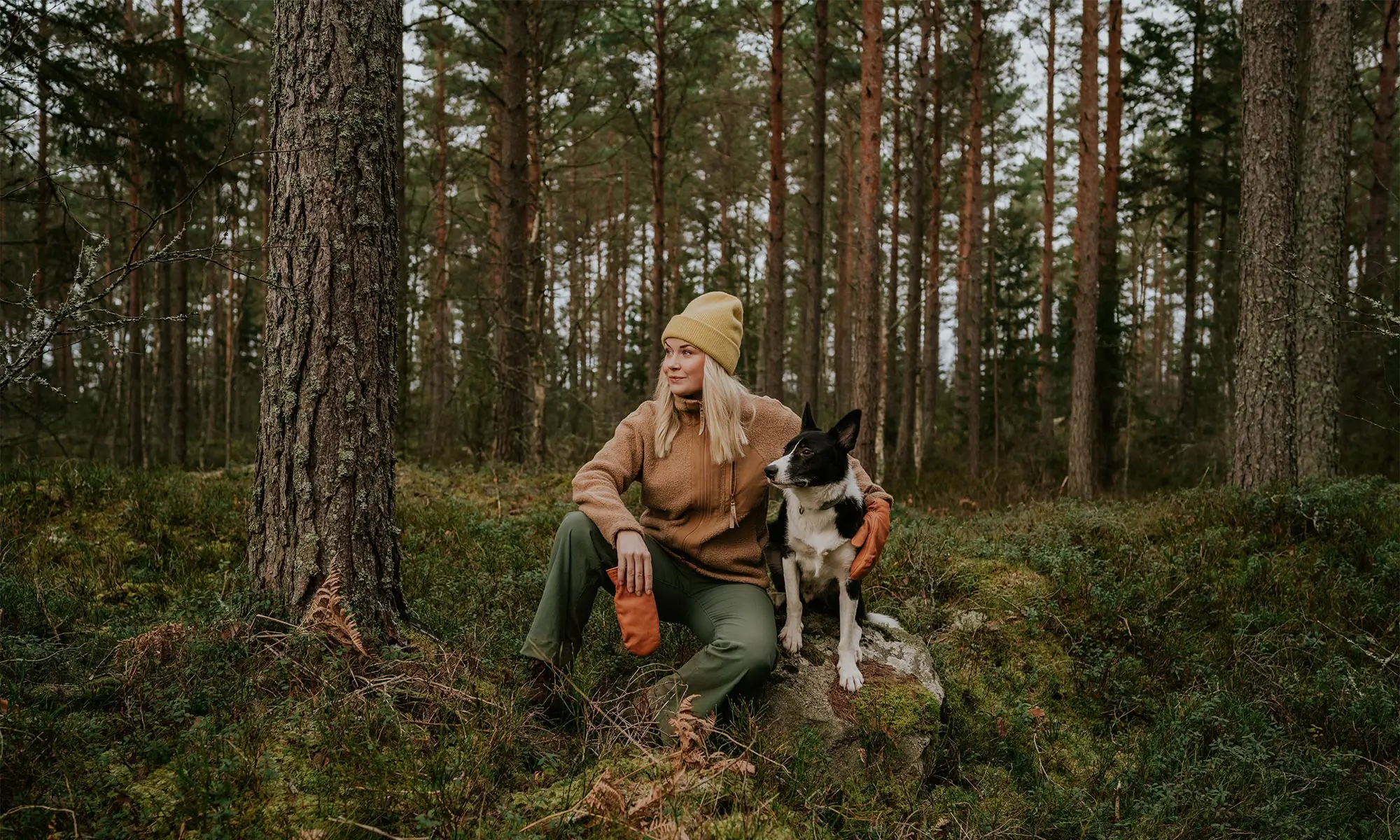 A dog and woman in the woods
